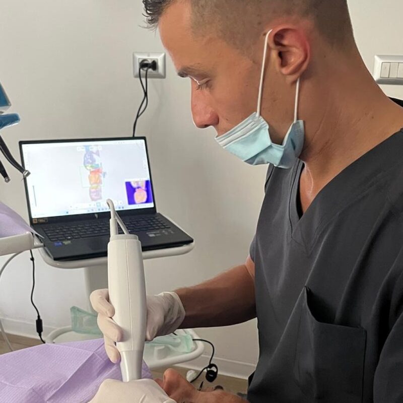 Il dott. Gianmarco Muzzi esegue un’impronta dentale digitale con lo scanner intraorale; sul portatile la scansione 3D dell’arcata